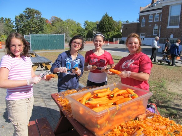 Student helpers get local carrots ready for school lunch